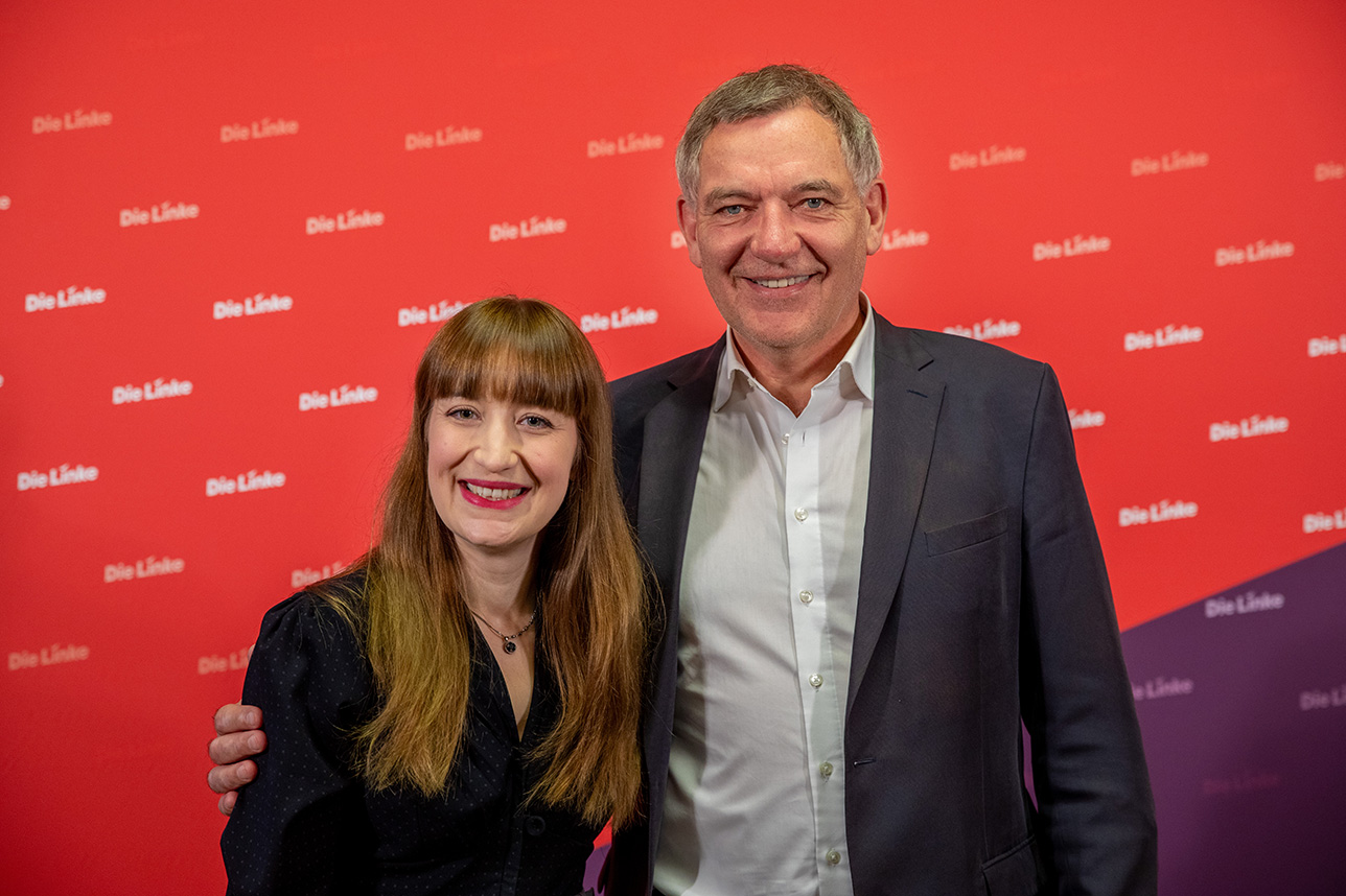 Die Spitzenkandidierenden Heidi Reichinnek (links) und Jan van Aken (rechts) vor einem roten Hintergrund