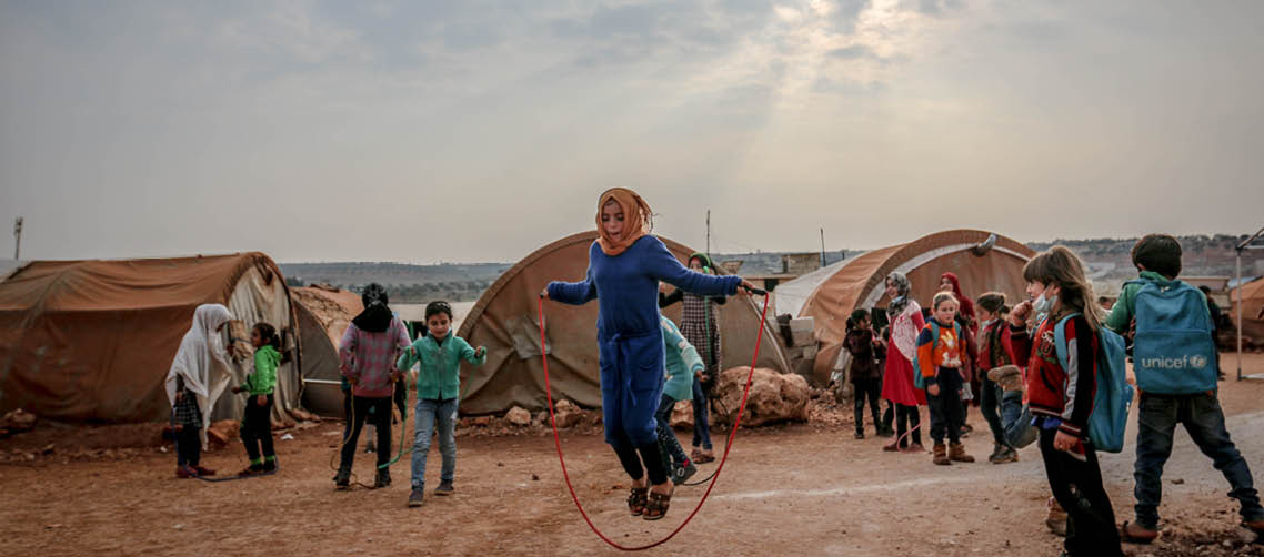 Geflüchtete Kinder spielen in einem Camp