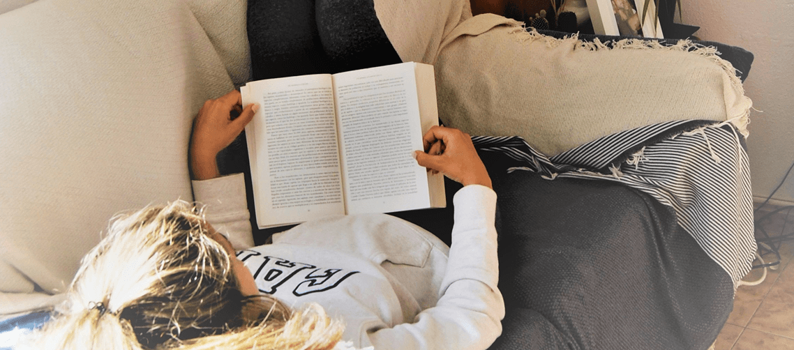 Wohnen_Header_1138x502__.png Frau liegt auf dem Sofa